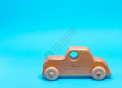 蓝色背景的木制儿童汽车车辆童年卡车手工送货木头黄色图片