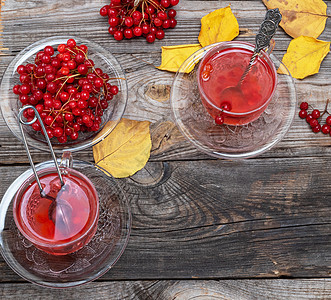 清茶 用鲜红的果实和玻璃杯中药品浆果乡村木头饮料季节叶子果汁飞碟预防图片