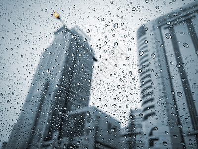 雨天在城市的汽车玻璃上下雨街道蓝色窗户建筑天气镜子季风季节墙纸雨滴图片