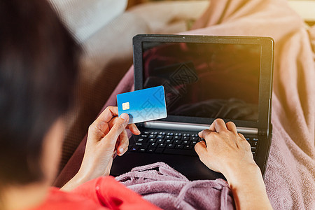 女人躺在沙发上 用平板电脑和信用卡从家里网上买东西女性电子商务技术银行业女孩女士购物信用支付笔记本图片