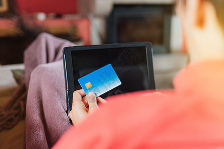 女人躺在沙发上 用平板电脑和信用卡从家里网上买东西银行业夫妻药片支付技术男人信用笔记本女性电子商务图片