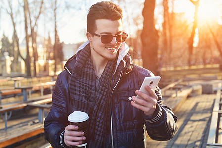 白种男人在街上看手机享受咖啡闲暇喜悦微笑幸福假期电话乐趣街道图片