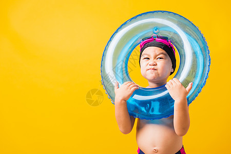 身着护目镜和泳衣的男孩 手持沙滩蓝色黄肿眼镜游泳幸福快乐孩子水池乐趣婴儿喜悦海滩图片