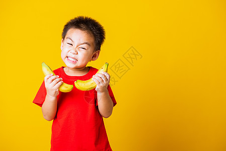 儿童或孩子可爱可爱的小男孩 有吸引力的笑容 玩游戏眼睛工作室电话喜悦婴儿快乐男生育儿香蕉水果图片