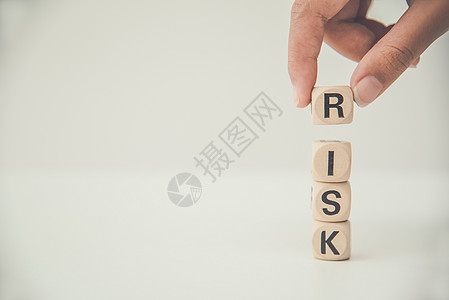 用“RISK”这个词来握住木块 概念风险管理图片