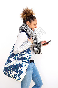 在白色背景下带袋和手机走路的年轻黑人青年妇女;图片