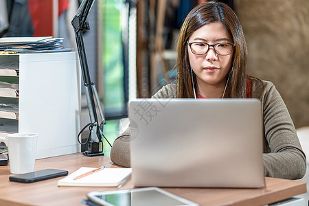 亚洲商业妇女使用技术笔记本电脑和从胡图人工作学习工人教育成功咖啡杯在线学生卧室女性女士图片