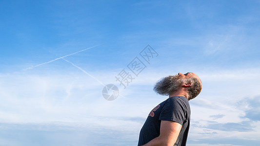 男人仰望着蓝色的天空图片