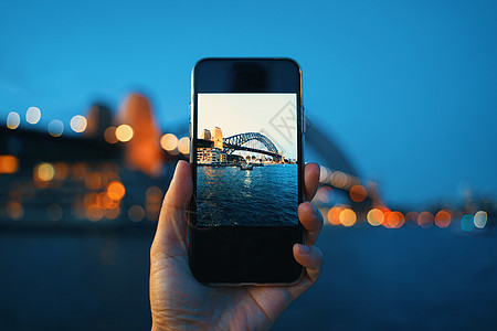 手持智能手机屏幕 拍摄悉尼港的相片图片