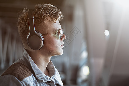 一位年轻时尚男子用耳机收听音乐的肖像 生活方式概念 音乐概念图片
