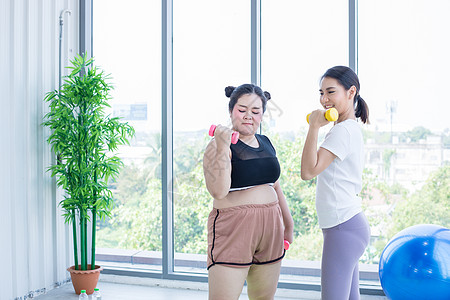 两个亚裔妇女在家里用哑巴操练实验室运动装女士女性成人药片房间运动健身房耳机图片