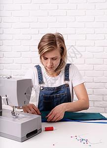 女裁缝在她工作室与纺织一起工作草图剪裁成人工艺设计师作坊商业创造力织物女孩设备高清图片素材