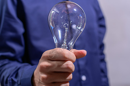 商务人士握着灯泡的手企业家想像力手指金融智力力量商务技术战略活力图片