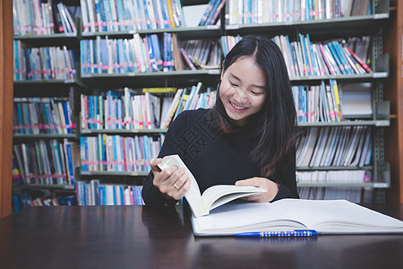 亚裔女学生阅读书籍和使用笔记本在解放组织读学生大学桌子幸福女士男人男性电脑团队写作图片