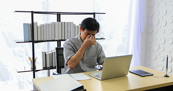 一名使用笔记本从事工作和经商的亚洲资深男子商务医院游戏休息疼痛商业男性偏头痛疾病宿醉图片