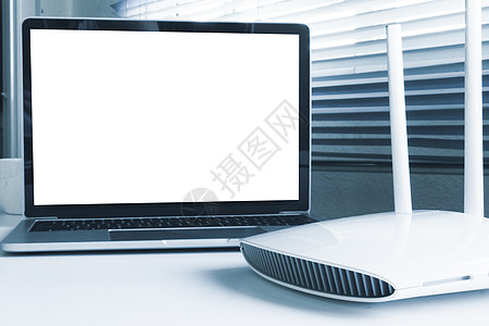 桌子上的空白屏幕膝上型电脑和路由器设备键盘细胞自由职业者互联网网关职场技术中心笔记本网站图片