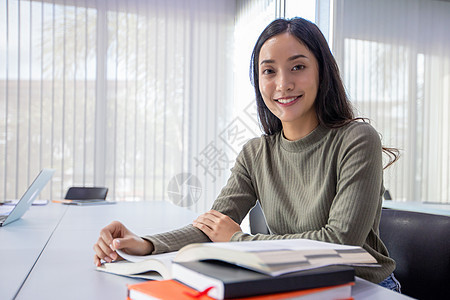 亚洲女学生微笑和阅读书以及使用笔记本f电脑青少年自由职业者学习团队技术教育成人女士女孩图片