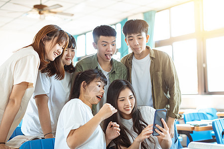 学生在课堂上看智能手机的快乐学生微笑同学电话男人朋友学习互联网技术学校团体图片