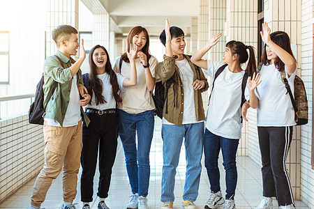 一群在大学沿走廊走来走去的快乐学生乐趣同学学校学习青少年朋友教育青年男人团队图片