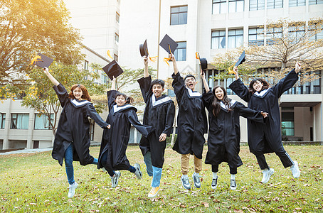 快乐学生在大学校园庆祝和跳跃毕业礼服中欢乐的学生庆典学校团体长袍女士证书友谊男人仪式教育图片