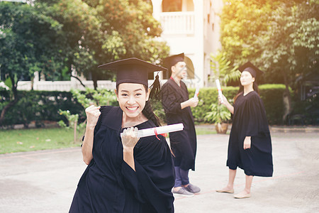 与朋友在后的朋友站在一起的快乐学生获得毕业文凭学士学校砂浆团体教育大学庆典微笑成就国际图片