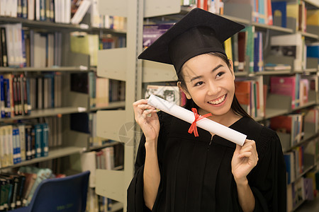 持有毕业证书的快乐研究生手头有文凭 教育学士学位成就女士大学学校微笑女性帽子学习幸福图片