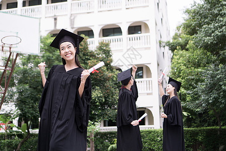 与朋友在后的朋友站在一起的快乐学生获得毕业文凭国际微笑学校成就大学学士教育砂浆庆典团体图片