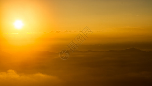 美丽的日出和山上喷雾的景象亮度爬坡场景日光薄雾地平线天空日落旅游阳光图片