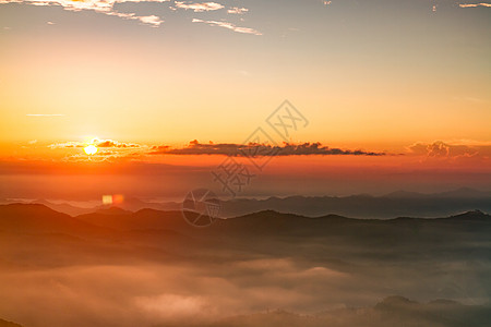 美丽的日出和山上喷雾的景象日落阳光旅行旅游日光薄雾漫游地平线亮度天空图片