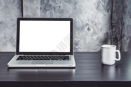 桌上有白色空白屏幕和白咖啡杯的笔记本电脑图片