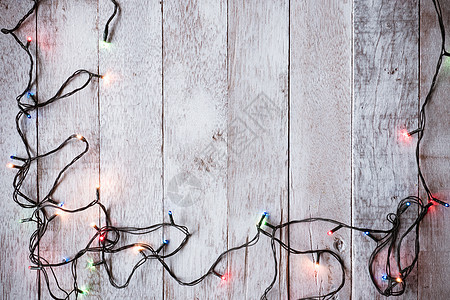 圣诞灯在木桌背景上最亮的景色假期季节桌子细绳红色辉光庆典木板图片