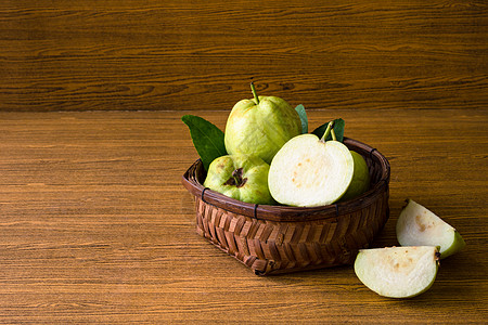 新鲜的瓜瓦果子放在木桌背景的篮子里叶子水果异国绿色白色产品营养热带植物情调图片