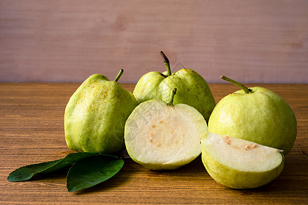木桌背景上新鲜的瓜瓦果白色甜点热带饮食叶子水果食物异国情调产品图片