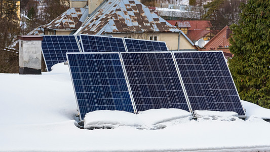 雪盖屋顶上的太阳能电池板阳光技术控制板房子集电极建筑光伏生态力量屋顶背景图片