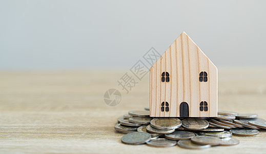 货币储蓄概念 木制房屋模型 硬币以折合金图片