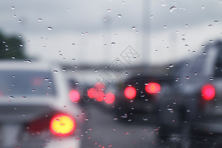 本底黑色交通车堵塞和雨滴水倒在玻璃上 并配有bokeh照明车图片