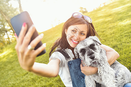 一个快乐的caucasian女人的肖像 她拥抱她的爱狗和图片