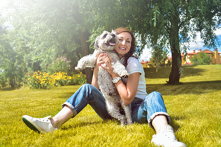 在阳光明媚的日子里 漂亮的成年白人快乐女人和她心爱的狗在公园里休息 女性躺在草地上 微笑着看着镜头 爱动物概念说谎女士宠物友谊房图片