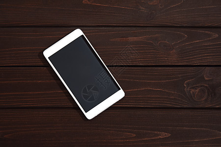 木桌背景上有空白屏幕的手机 木旧木板复古纹理背景上的智能手机 顶视图图片