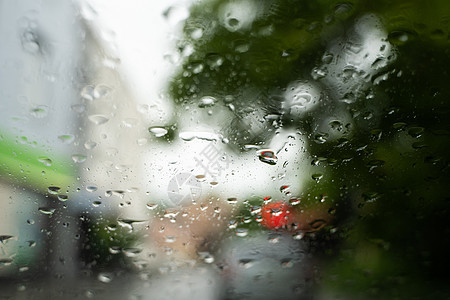 雨滴在挡风玻璃上 背景的夜晚城市灯光模糊不清驾驶液体玻璃大灯天气车辆摄影反射蓝色交通图片