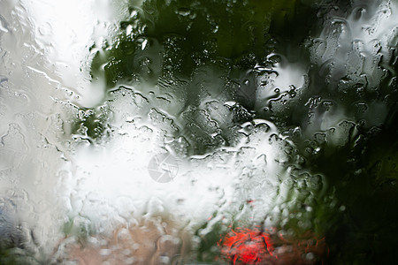 雨滴在挡风玻璃上 背景的夜晚城市灯光模糊不清天气旅行运输驾驶大灯下雨风暴蓝色液体车辆图片