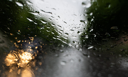 雨滴在挡风玻璃上 背景的夜晚城市灯光模糊不清驾驶摄影天气车辆旅行交通玻璃下雨运输窗户图片