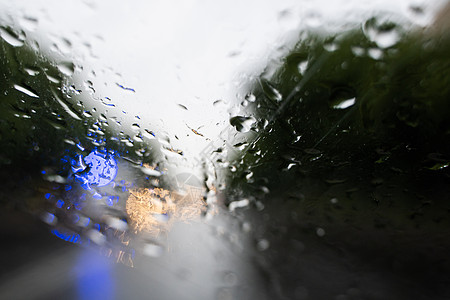 雨滴在挡风玻璃上 背景的夜晚城市灯光模糊不清液体街道下雨摄影天空风暴大灯反射驾驶交通图片