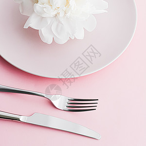 餐盘和餐具 配有小鲜花作为婚礼装饰品 放在粉红色背景 活动装饰最上桌菜以及甜点菜单新娘假期牡丹花朵厨师盘子广告奢华推广礼物图片