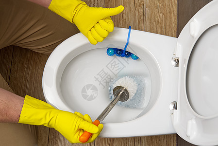 男子清洁厕所 管家作为厕所的清洁工 刷马桶以保持清洁和卫生 清洁马桶 保洁服务理念图片