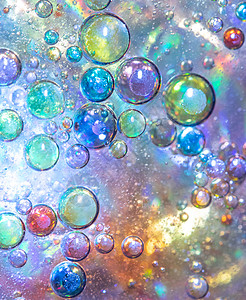 圆形水滴背景的沐浴水泡沫泡沫的特写气泡星系乐趣星星圆圈彩虹液体反射蓝色星云背景