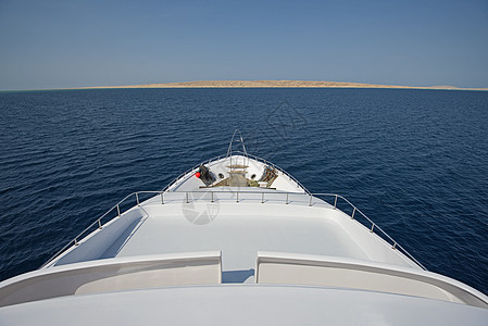 在一艘大型游艇的船首上观光假期船舶甲板旅行巡航地平线栏杆白色木头海景图片