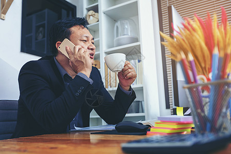 身穿西装的商务人士在电话上聊天 在电脑上工作 忙e技术商务咨询互联网文档经理谈判网络套装交易图片