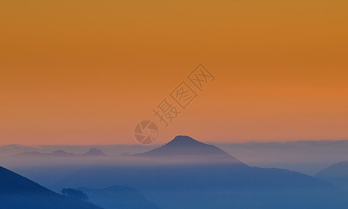 日出时雾中山丘图片