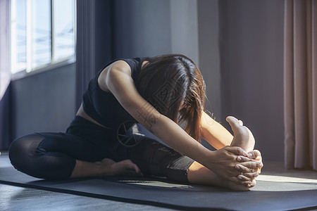 华丽年轻女子在室内做瑜伽的肖像班级女性成人工作室平衡运动装训练体操姿势重量图片